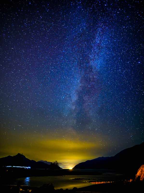 A star-filled sky above Porteau Cove with a bright streak